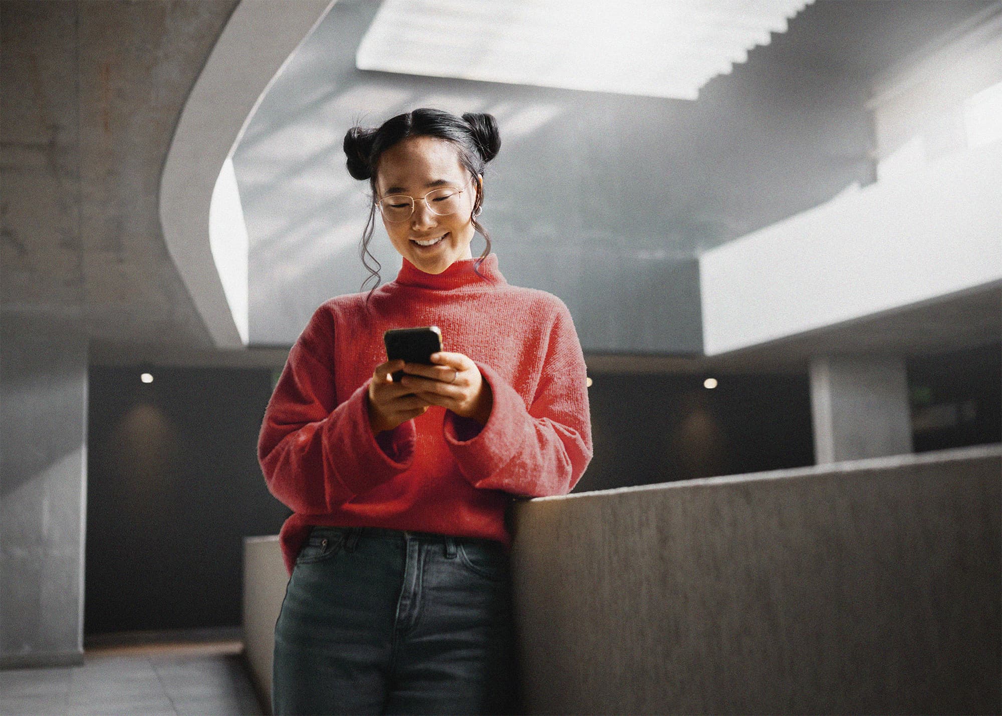 Person smiling at phone in red sweater